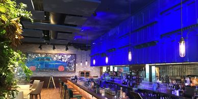 Modern bar with blue lighting and stylish seating.