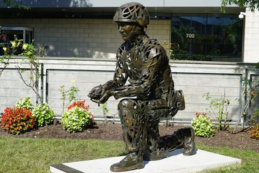 Bronze Statue of Soldier kneeling holding dog tags. In the United Network of Organ Sharing Memorial 