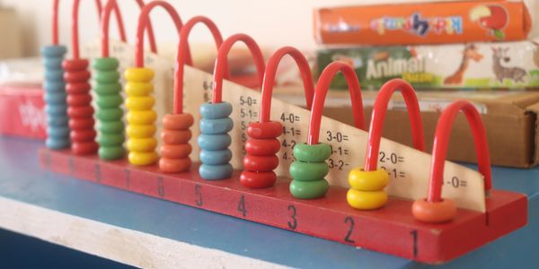 Colorful wooden beads on a red math teaching abacus toy with subtraction problems.
