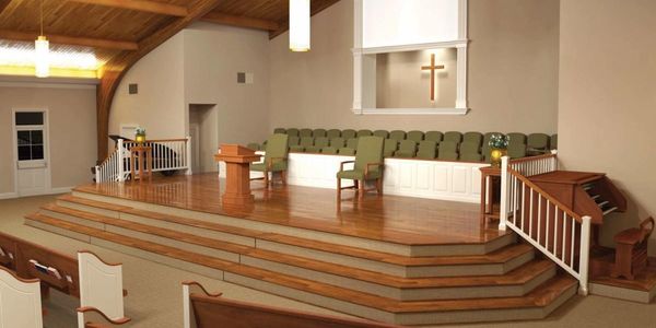 Empty church stage with chairs and cross.