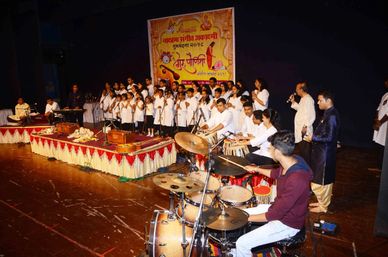 A music event with a choir and instrumentalists performing on stage.