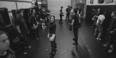 People in a gym preparing for a boxing or martial arts class.