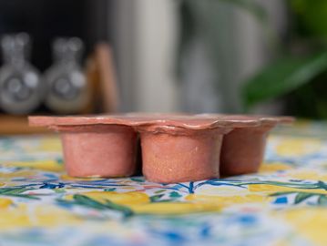 Handmade muffin pan with pink glaze finish.