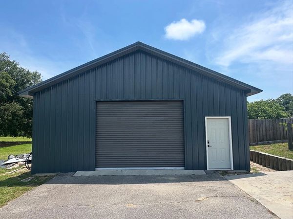 Workshop shed renovation with garage door install, window installation, and new siding 