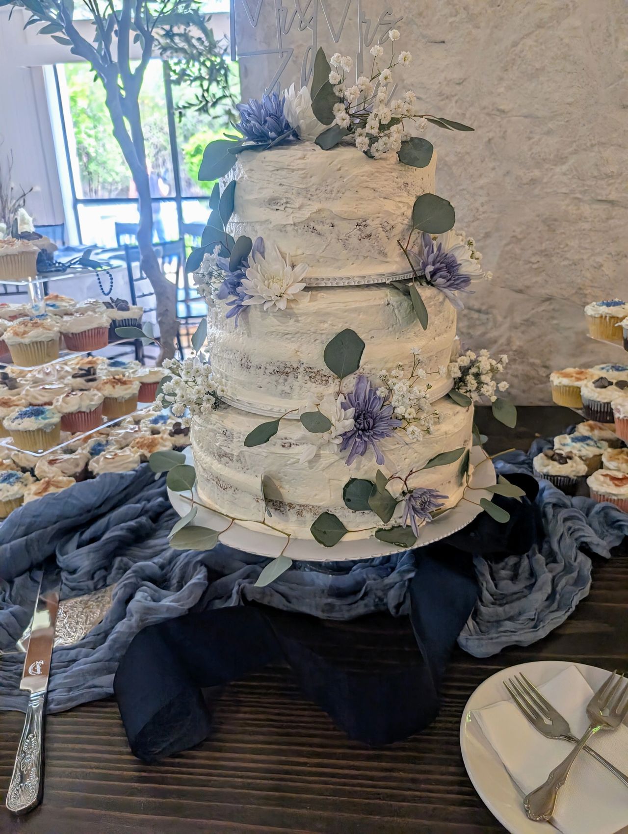 Rustic-look wedding cake with blue flowers