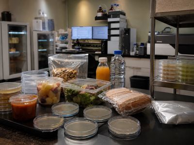 Lab table with food samples and petri dishes.