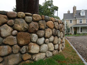 Low, rustic stone wall along a property line.