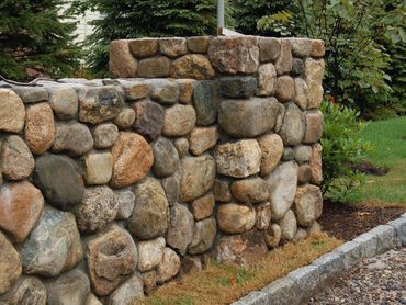 Close-up of large rounded river rock retaining wall.
