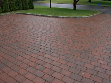 Driveway or patio paved with red clay brick pavers.
