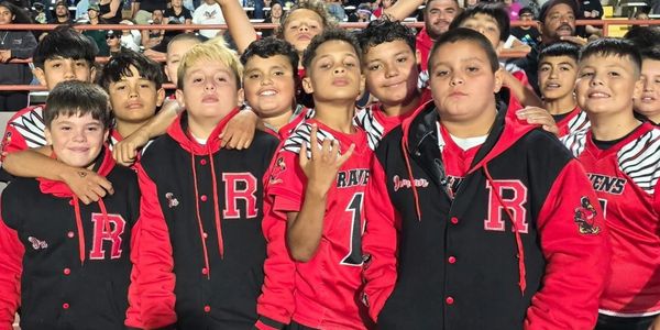 A group of boys wearing red and black sports jackets posing together.
