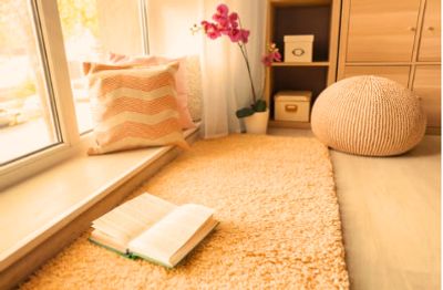 Cozy reading nook with soft rug, cushions, and natural light.