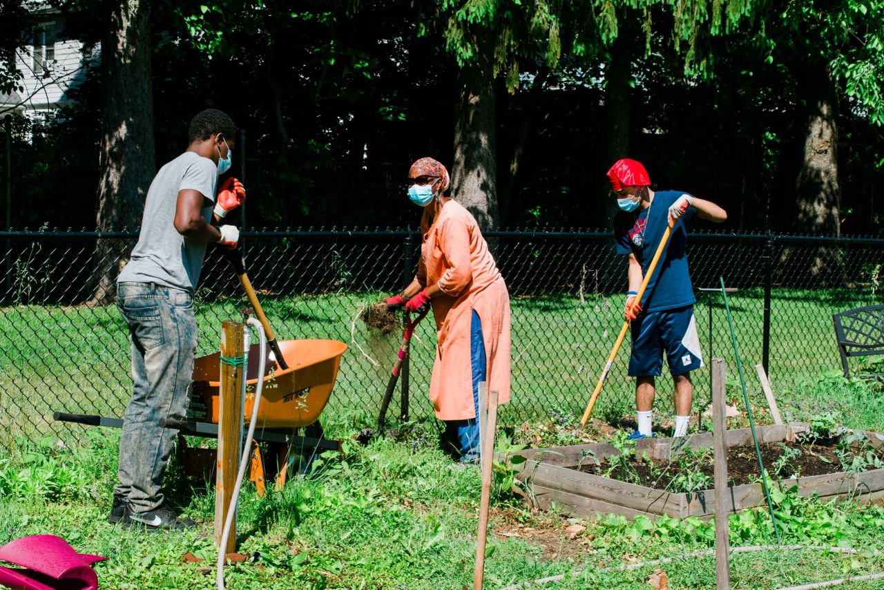 Bernard Harvey, Sister Anna Muhammed, and Escalera  planting in early June while wearing masks.