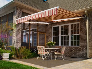 Red and white striped retractable awning over patio providing shade.