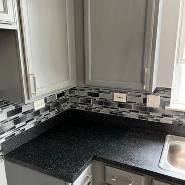 After photo of kitchen cabinet resurface with resurfaced countertop.  “Ebony Stone” multi-stone.