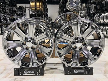 Two shiny chrome car rims displayed side by side.