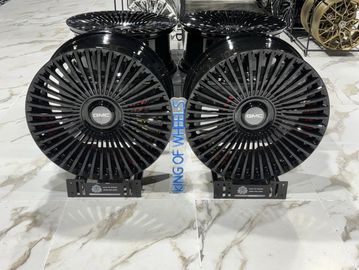 Two black GMC custom alloy wheels displayed on a marble floor.