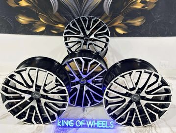 Four stylish alloy wheels displayed with a neon sign.