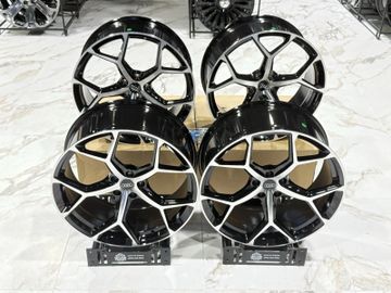 Set of four black and silver Audi alloy wheels displayed indoors.