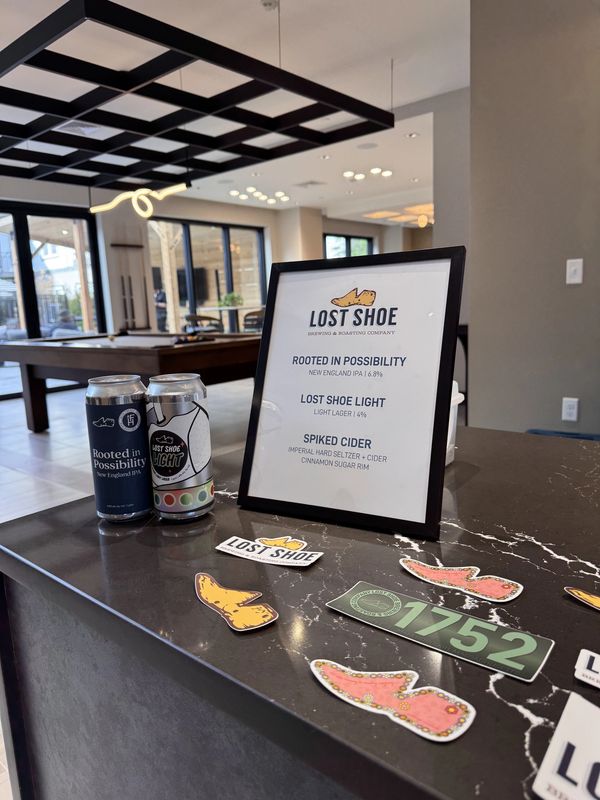 Close-up of Lost Shoe table setup with beer cans and event materials.