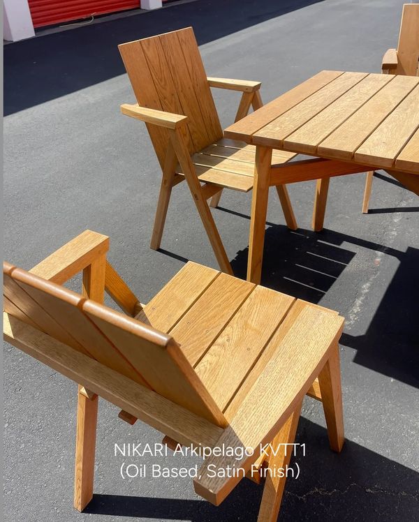 Wooden chairs and table with satin finish on pavement.