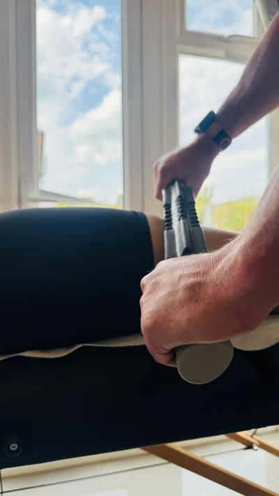 Person exercising with a barbell near a window on a sunny day.