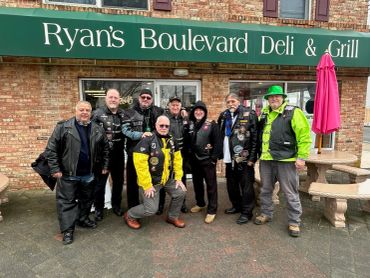Group of people posing outside Ryan's Boulevard Deli &amp; Grill.