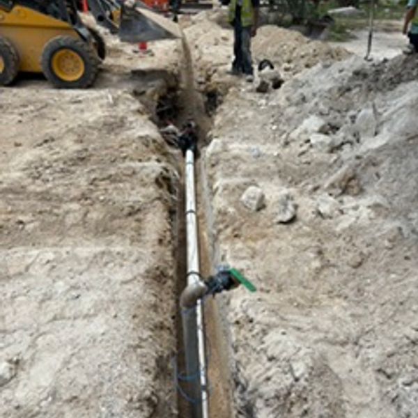 Construction workers laying underground pipes.