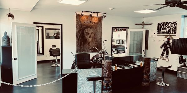 Interior of a tattoo studio with tribal decor and a motorcycle.