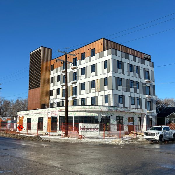 Modern multi-story building under construction with clear blue sky.