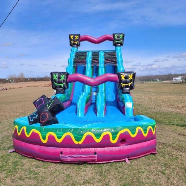 Colorful inflatable slide with playful designs set outdoors on grass.