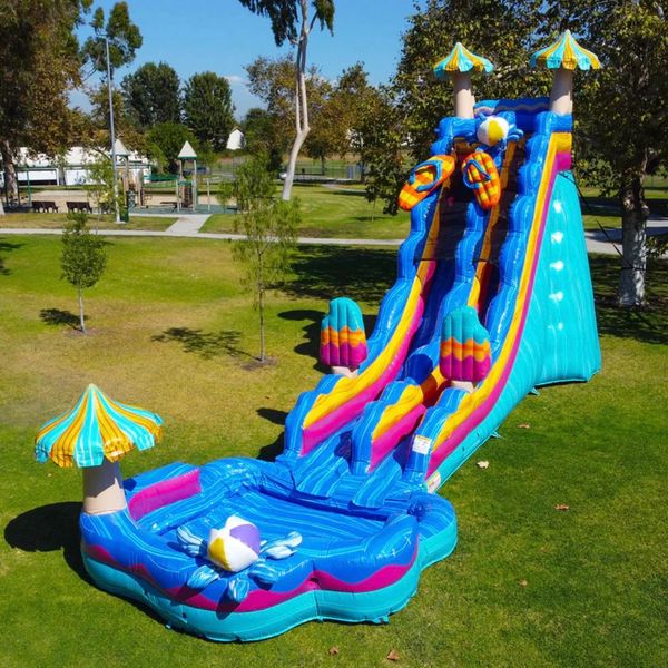 Colorful inflatable water slide set up in a park on green grass.