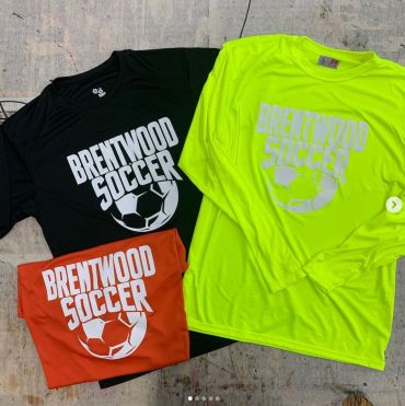 Three Brentwood Soccer shirts in black, neon yellow, and orange.
