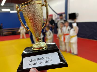 Someone holding a trophy that says Ajax Budokan Monthly Shiai