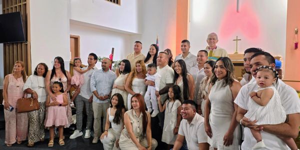 A large family group photo inside a church with smiling faces.