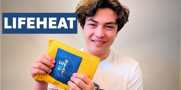 Young man holding a yellow heat pack with LIFEHEAT branding.