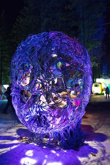 People inside a human head light sculpture at Snow Globe Musica Festival in South Lake Tahoe, CA 