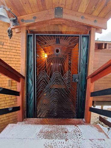 A custom steel entrance gate with mountain and sun imagery installed in Rubicon Bay, CA