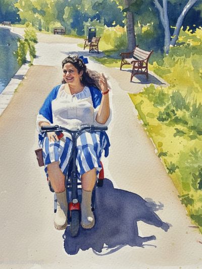 Lady sat on her mobility scooter. She wears stripped white and blue trousers and and a white top. 