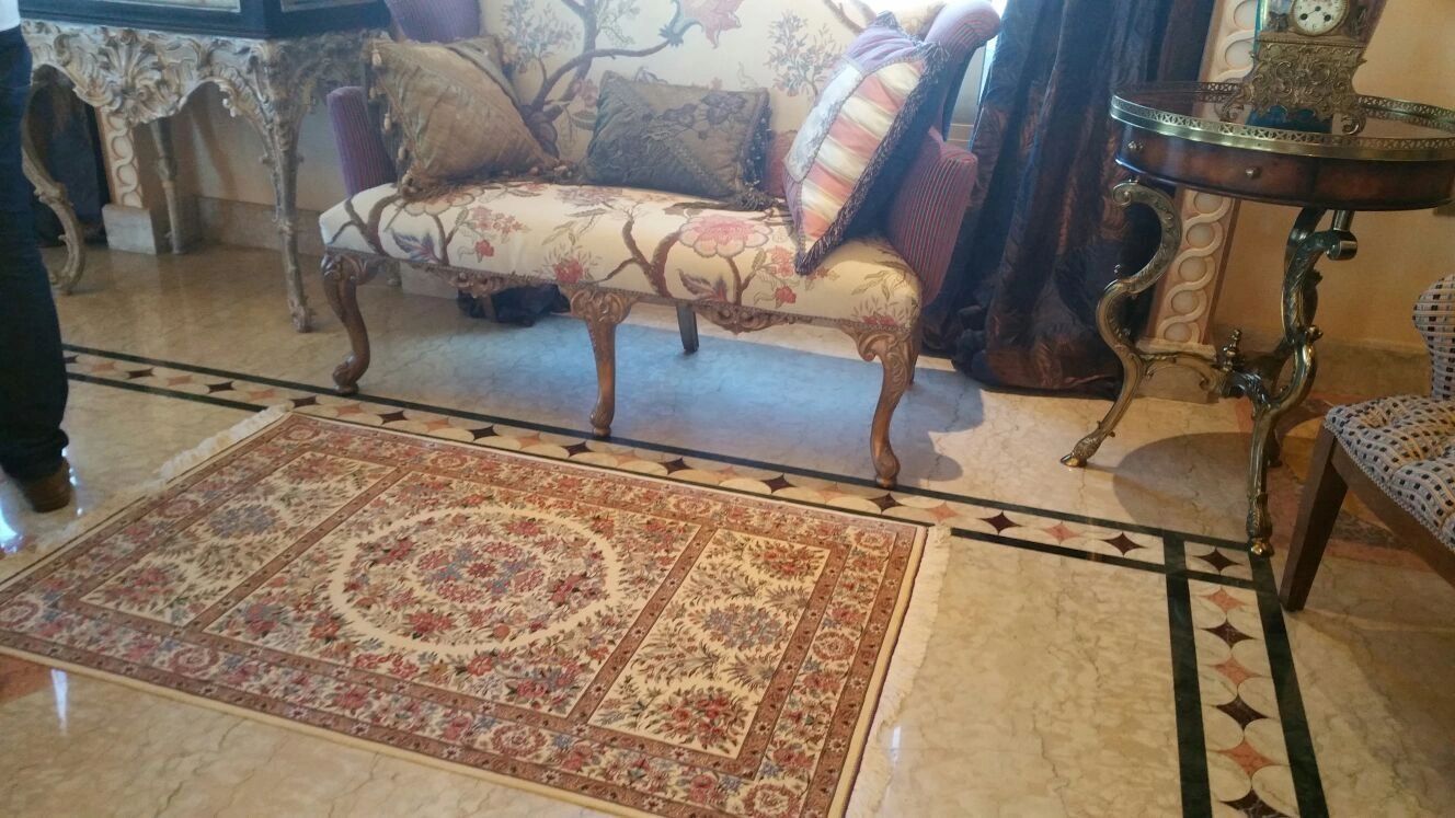 Beautiful Qom silk handmade carpet. This area rug is placed in a hallway with furniture. 