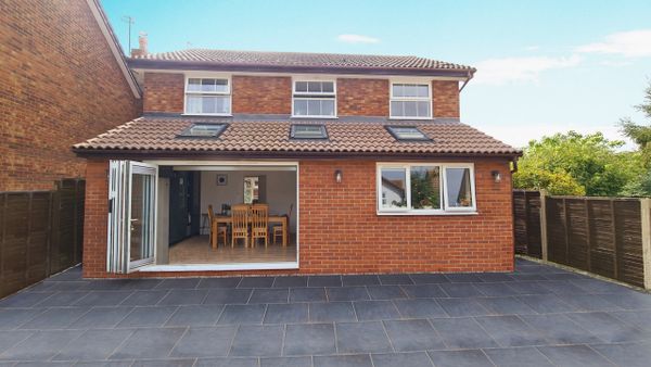 Modern brick house with large patio and open dining area.