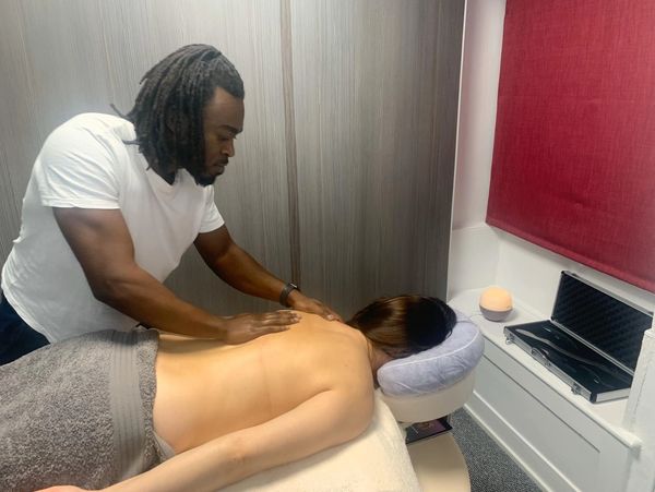 A massage therapist offering a back massage