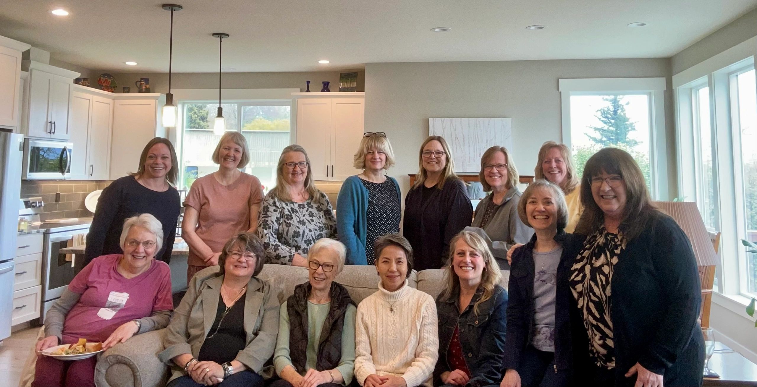 Group of smiling women gathered in a cozy home setting.