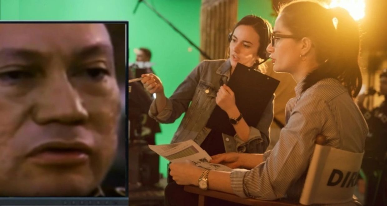 Two women discussing a film scene on set with a monitor showing a close-up face.
