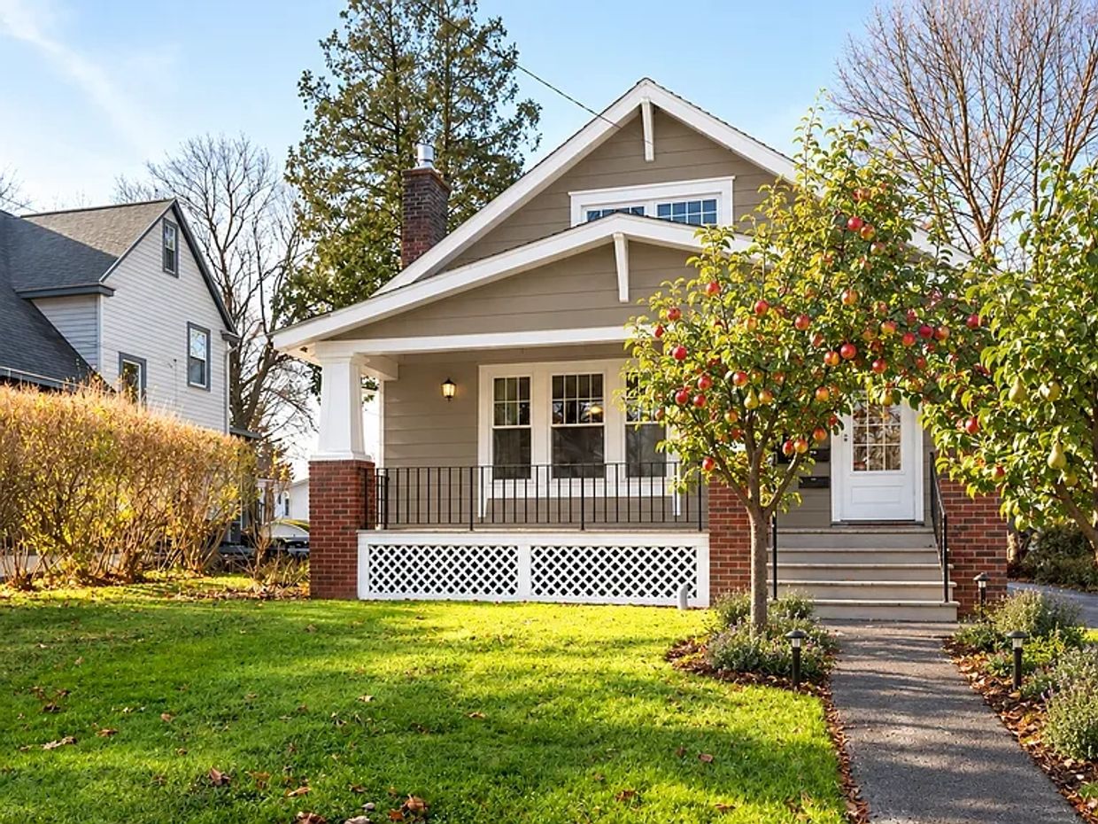 Cozy house with a porch and fruit trees.