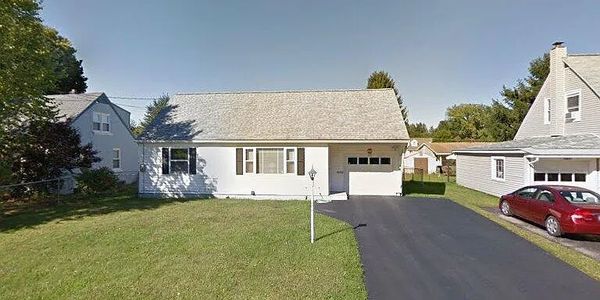 Single-story house with a garage and driveway in a suburban neighborhood.