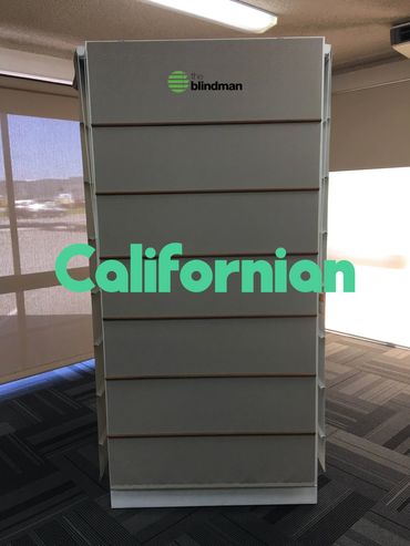 A slatwall display stand branded 'the blindman' in an indoor space.