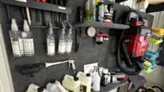 Organized wall-mounted storage with cleaning and maintenance supplies.