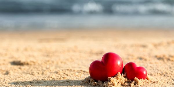 Two red hearts in the sand on the beach