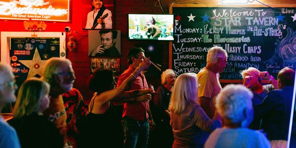 People enjoying a lively night at a bar with live music and colorful lighting.