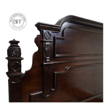 Ornate dark wood headboard with intricate carvings and polished finish.